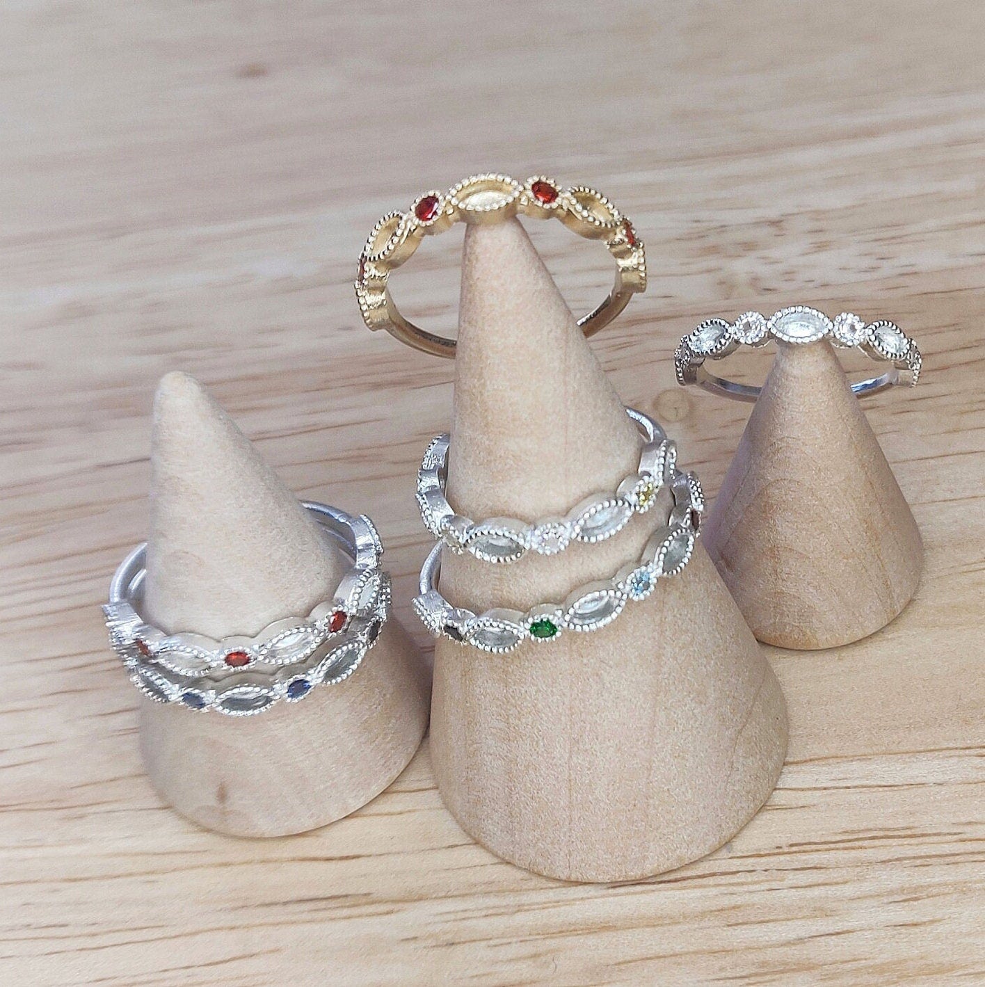 Wooden cones with gold and silver birthstone marquise eternity rings for breastmilk jewellery.