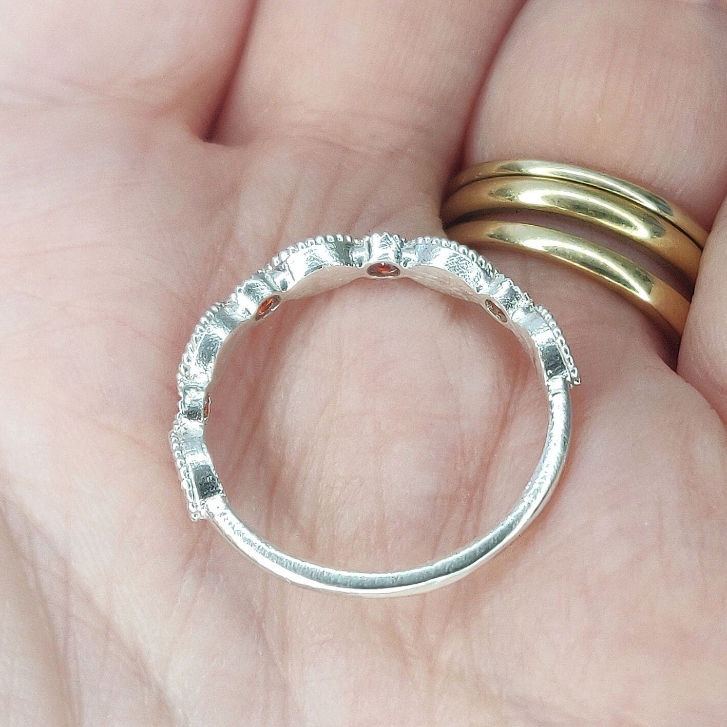 An open hand with a silver eternity ring in the palm.