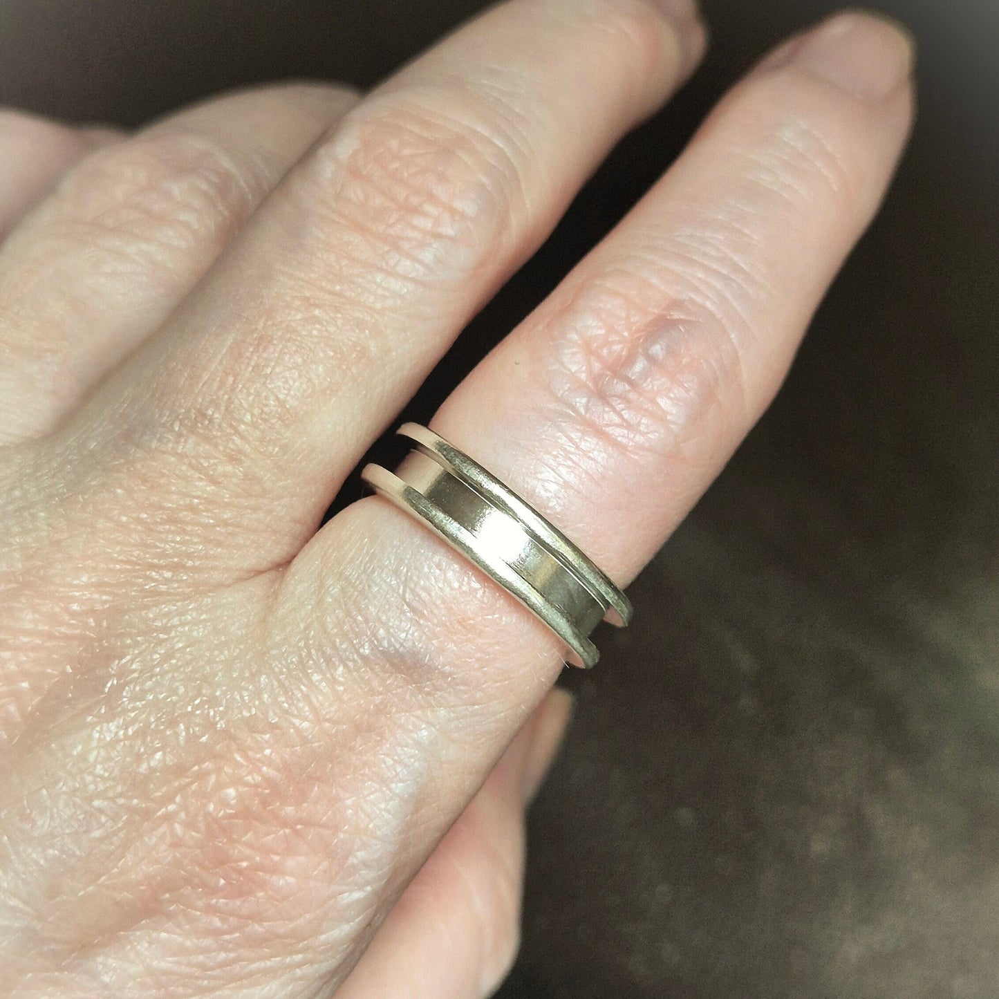 Silver Channel Ring Being Worn On A Finger