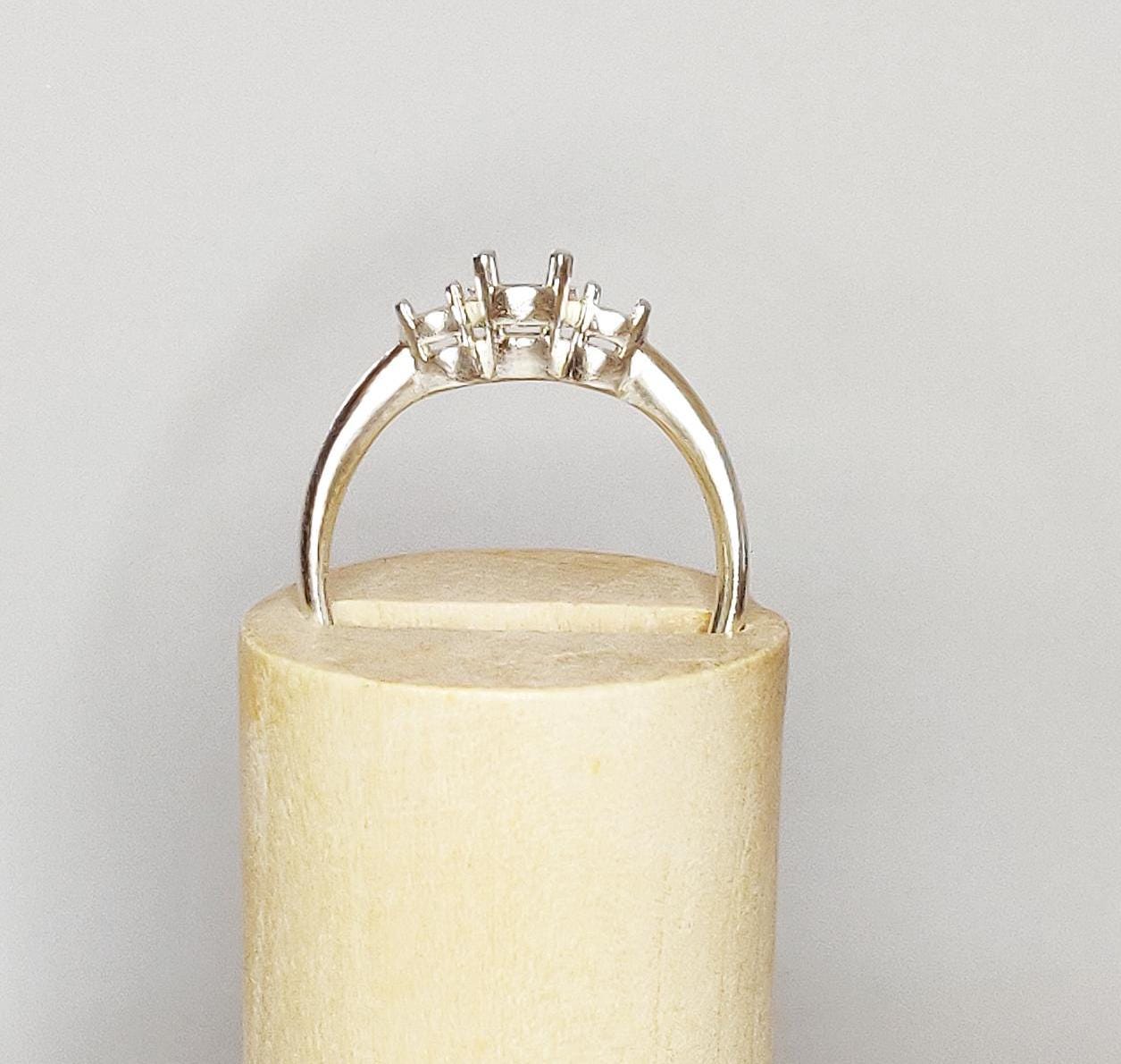 3 stone ring blank in silver on a wooden display cone.