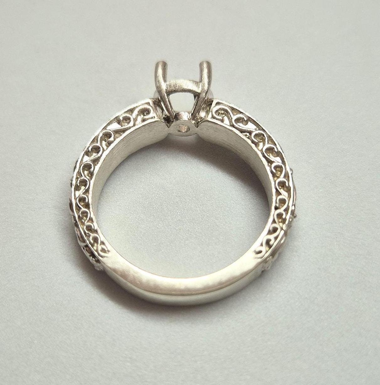 Silver antique style ring on a white background.