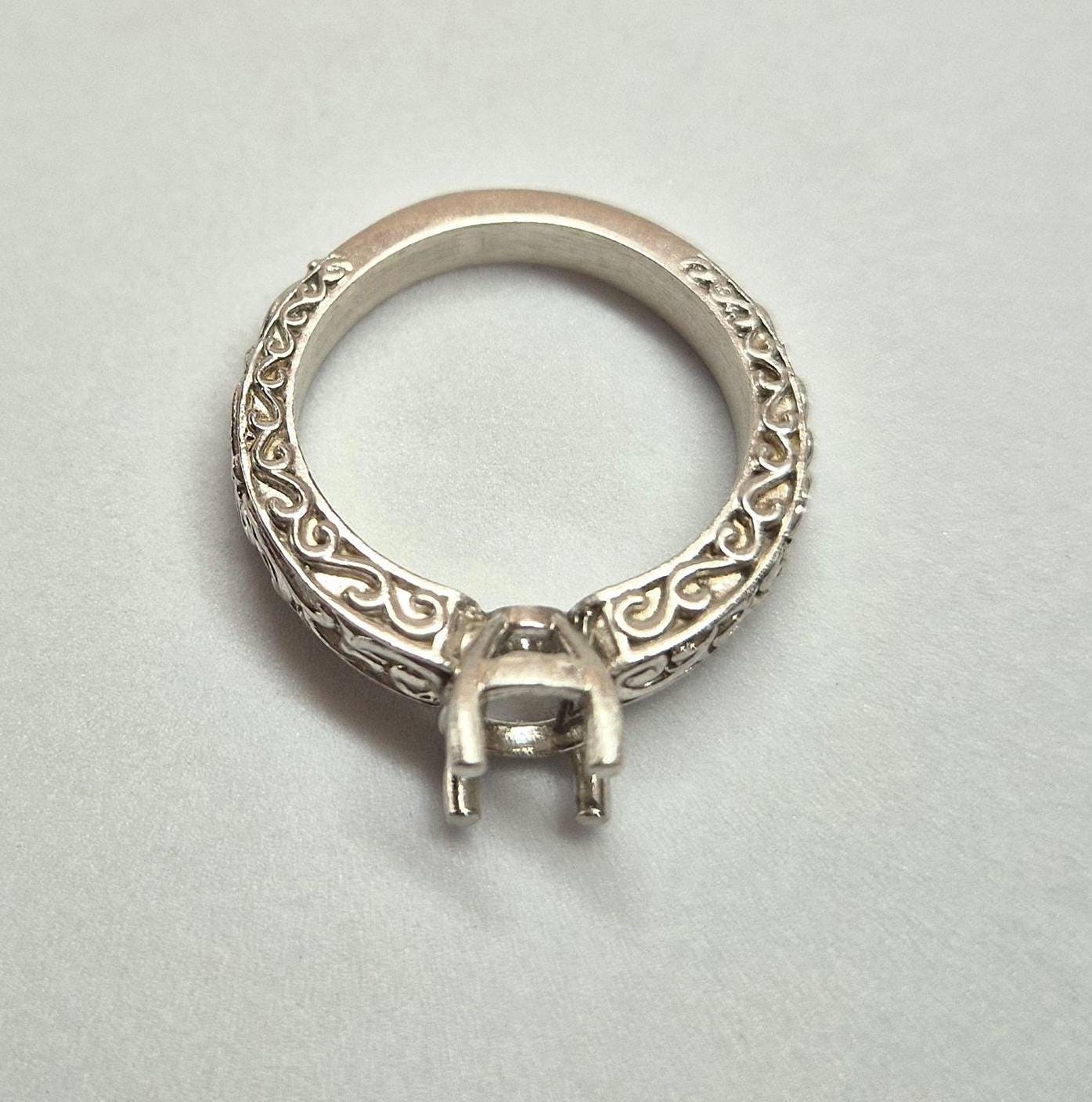 Inverted view of a silver georgian style ring on a white background.