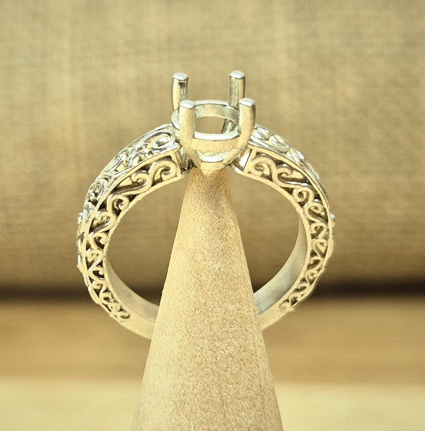 Silver engagement antique style ring on a display stand.