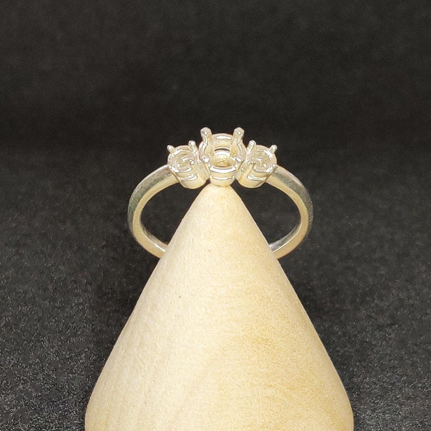 Through finger view of a 3 round stone prong setting ring
