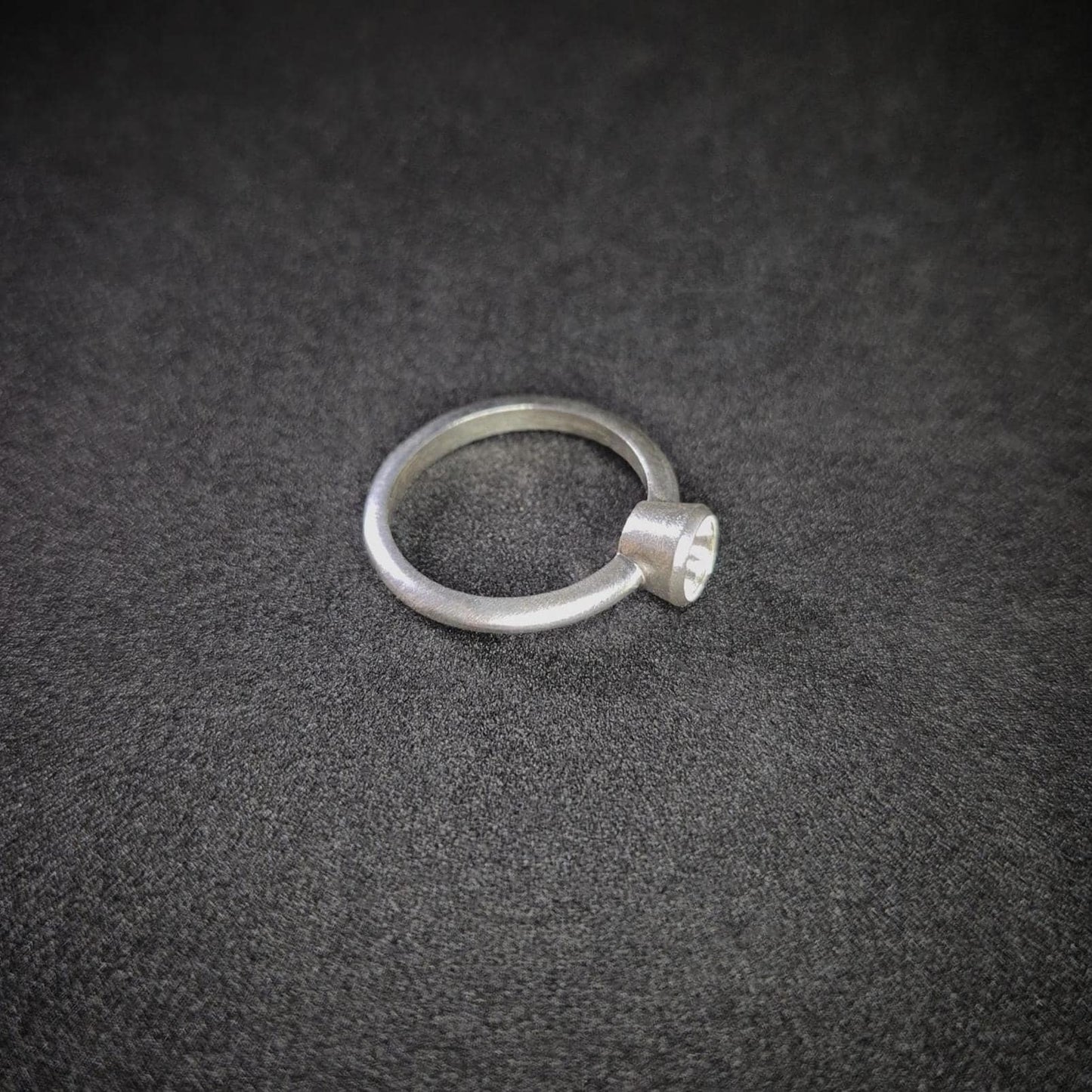 Right View of a Silver Bezel Ring on a Dark Background.