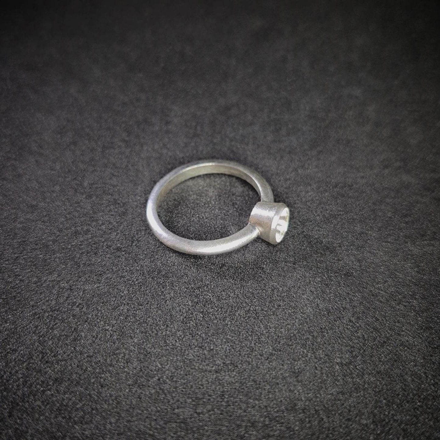Right View of a Silver Bezel Ring on a Dark Background.