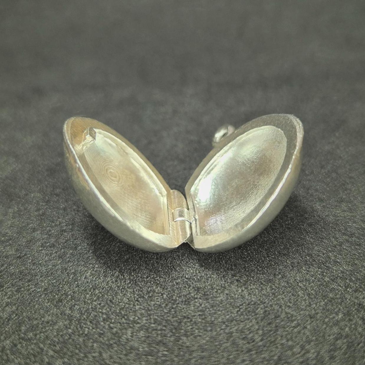 Open Round Silver Locket on a Dark Background.