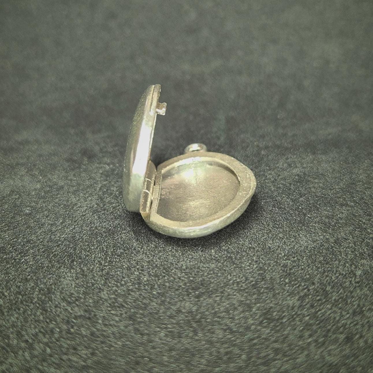 Bottom View of an Open Oval Silver Locket.