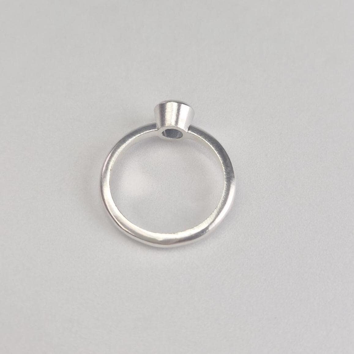 Silver Rubover Setting Ring on a White Background.