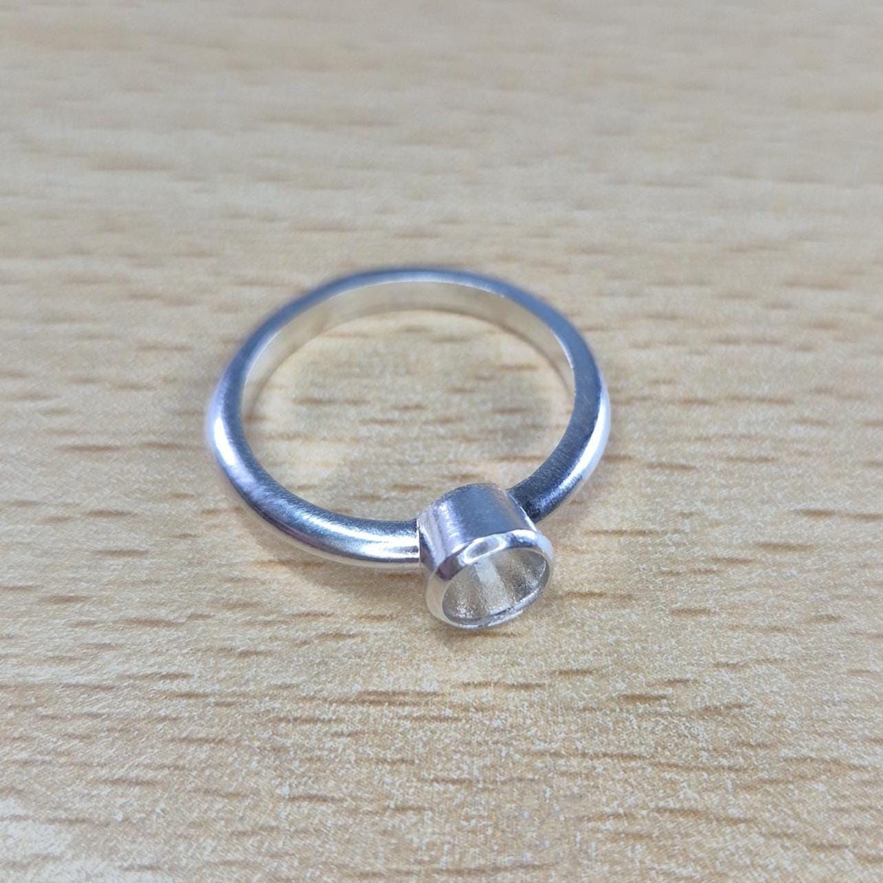Silver Open Bezel Ring on a Wooden Background