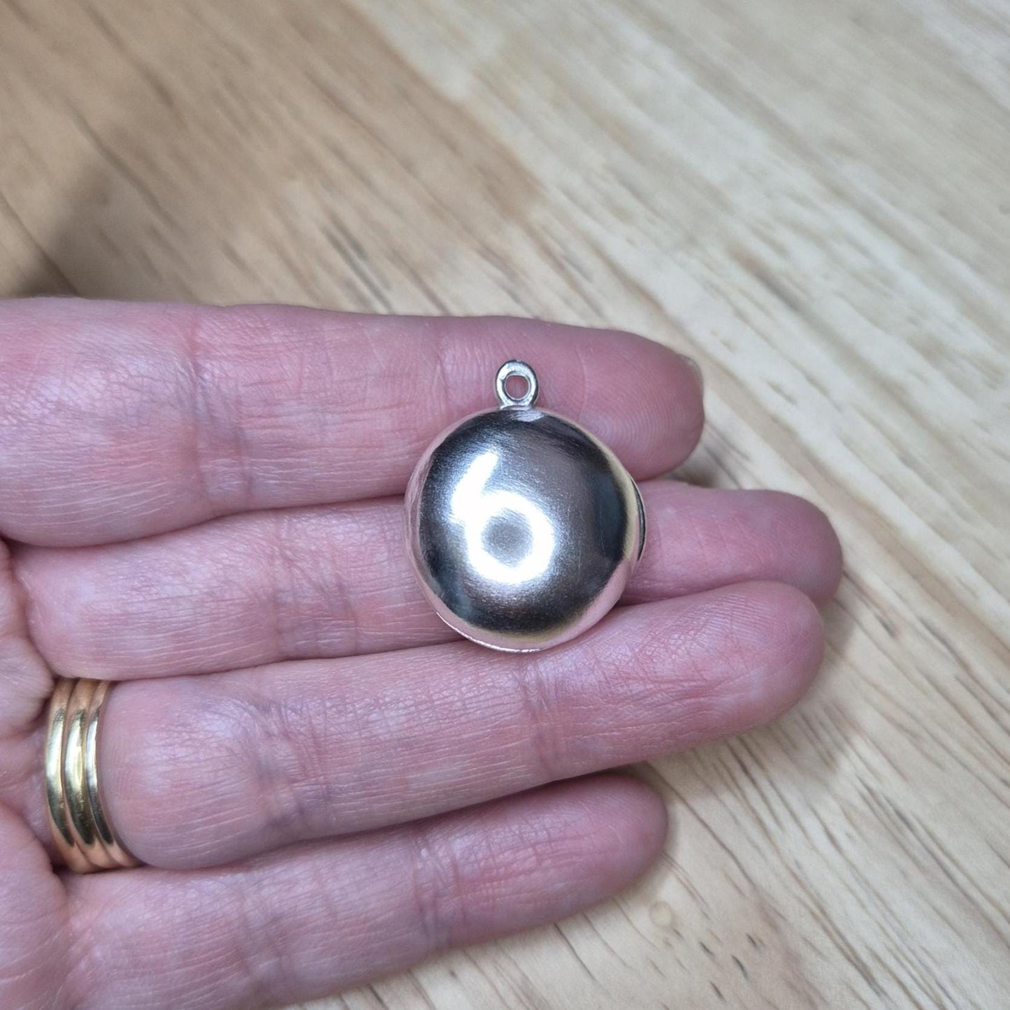 Closed Round Silver Locket in a Hand.