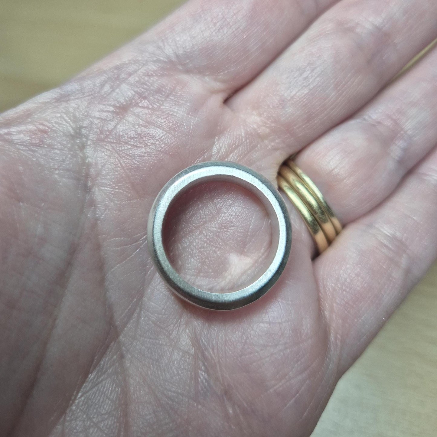 Top-down view of a half channel ring resting in a palm, highlighting the flat band profile and inner channel detail.