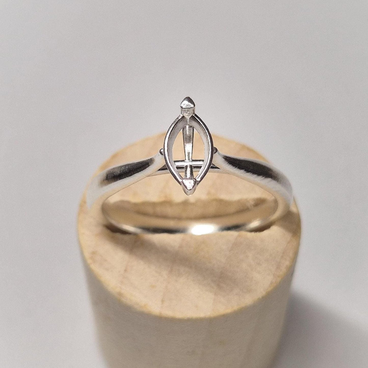 Front view of a marquise setting ring blank on a wood block, highlighting the 2-prong claw and cathedral design.