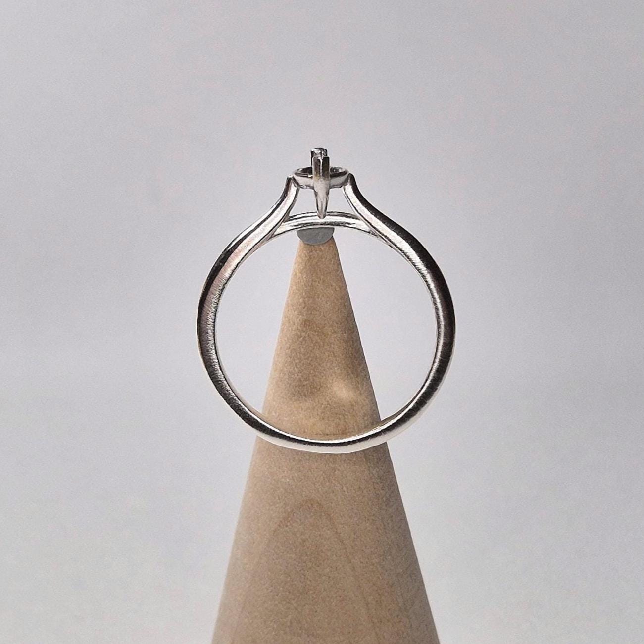 Ring blank standing vertically on a wooden cone, showing the open setting and elegant cathedral arch of the band.