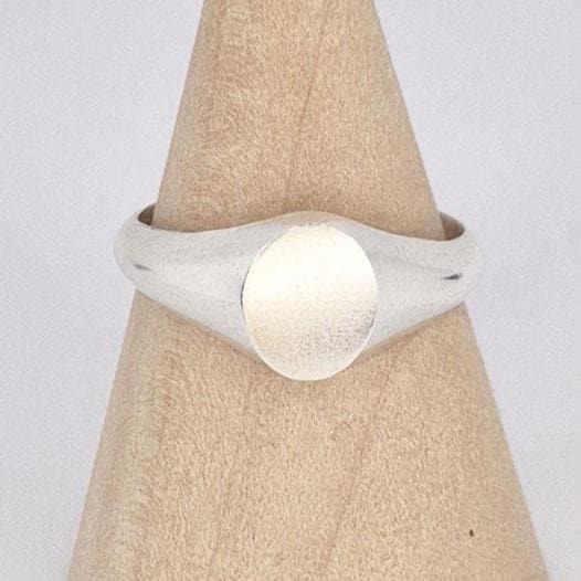 Close-up of oval signet ring face showing brushed texture and polished silver edges