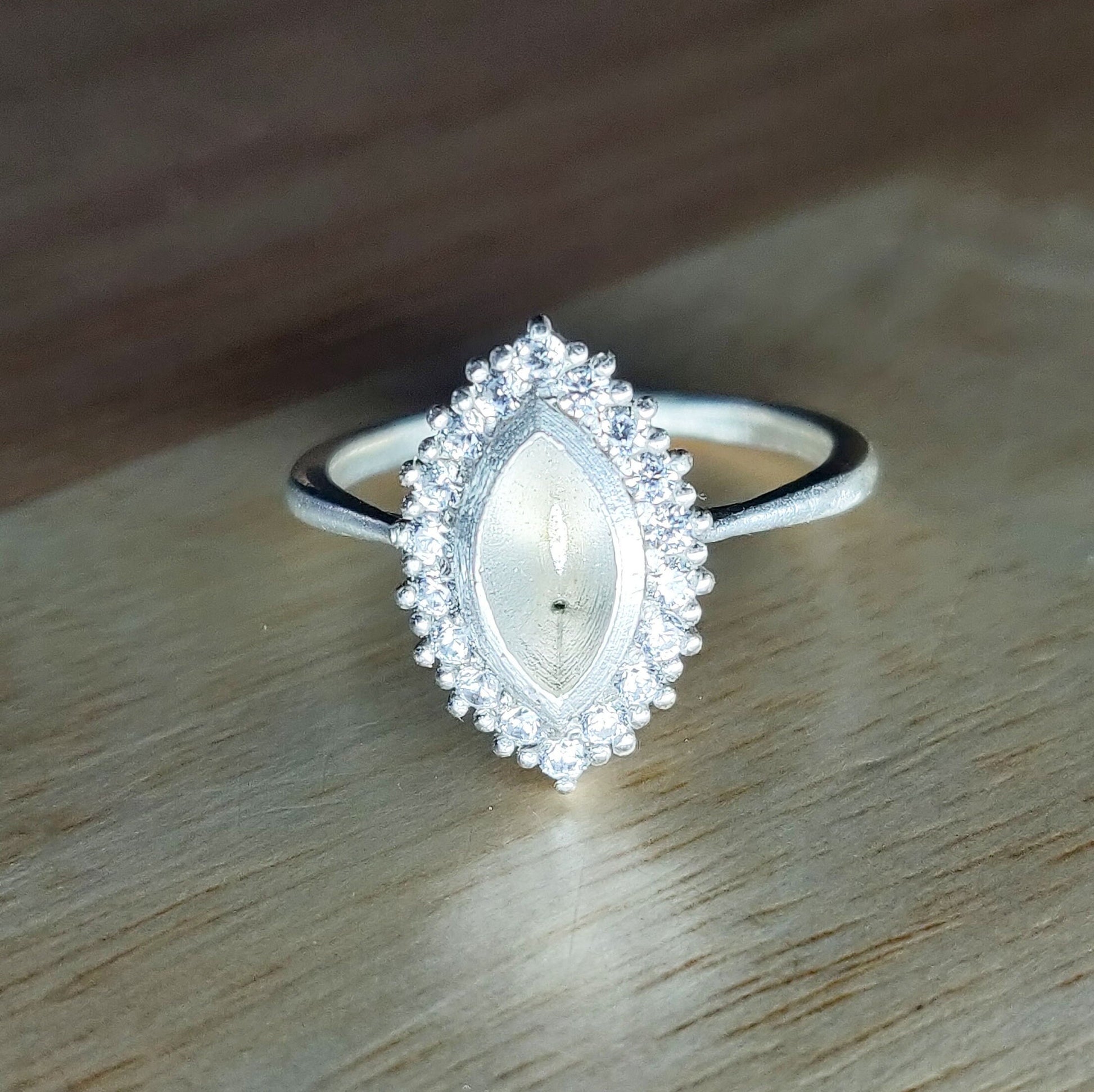 Bezel Set Cluster Marquise Semi Mount Silver Ring on a Wooden Background.