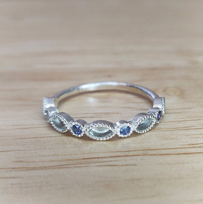Sapphire Marquise and Brilliant cut stone eternity ring on a wooden background.