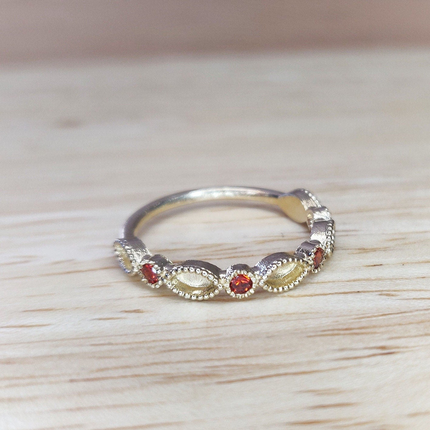 Angled view of gold minimalist eternity ring on a wooden table.