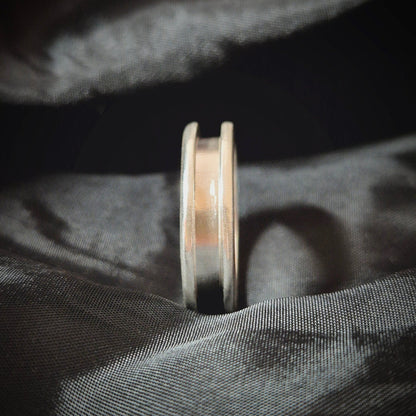 Side View Of A Silver Channel Ring on a Black Sheet
