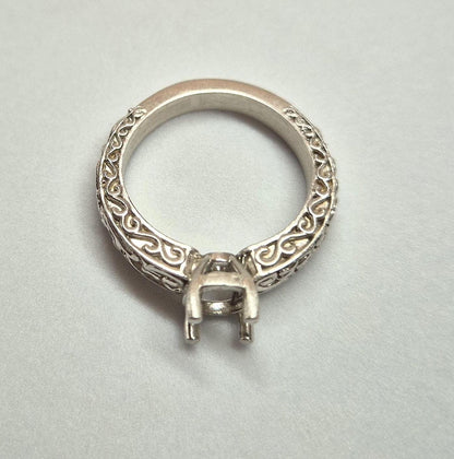 Inverted view of a silver georgian style ring on a white background.