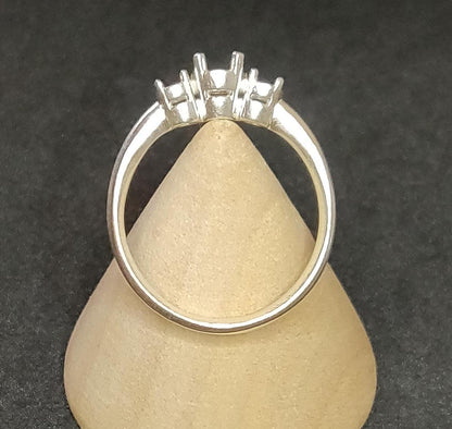 3 stone prong ring blank in silver on a wooden display cone.