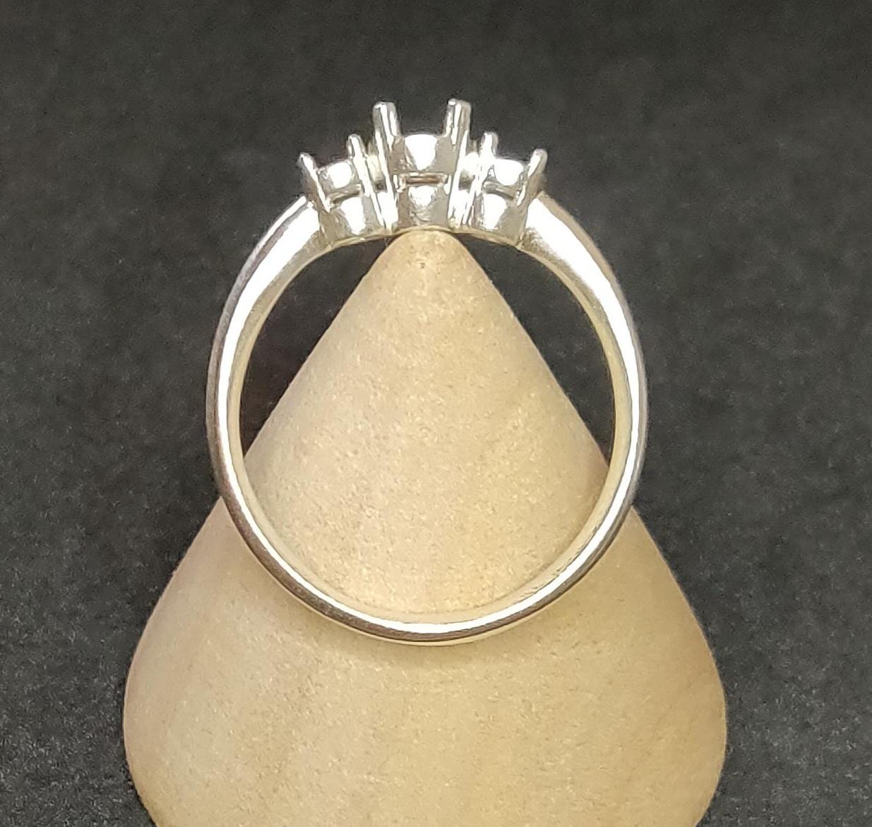 3 stone prong ring blank in silver on a wooden display cone.