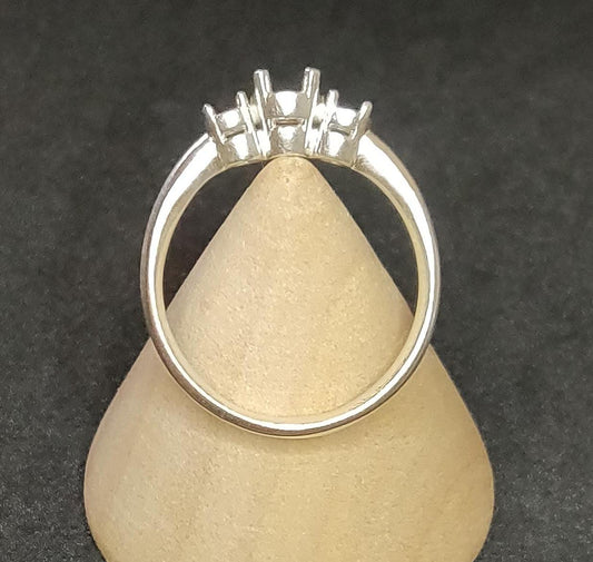 3 stone prong ring blank in silver on a wooden display cone.