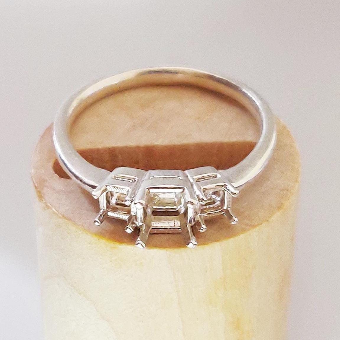 3 princess stone ring with gallery rails on a display block