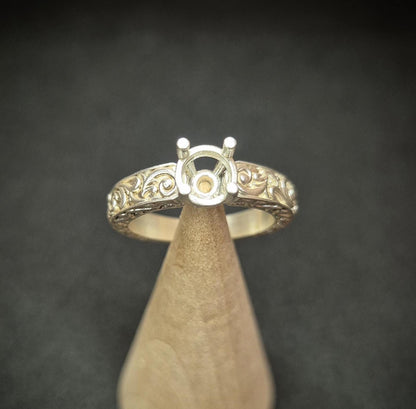 Top view of round gem setting on an antique styled silver ring.