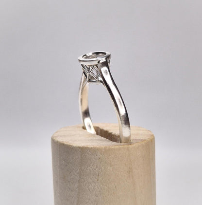 Side view of a cathedral shank ring with a basket bezel.