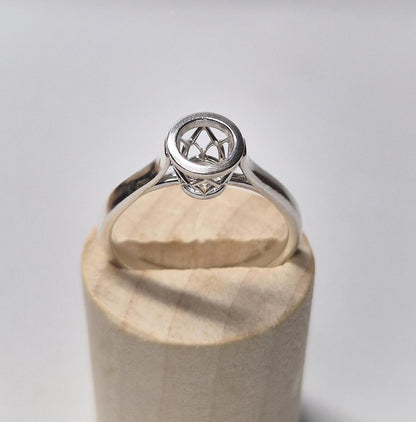 Top view of a basket bezel cathedral shank ring in a wooden display.