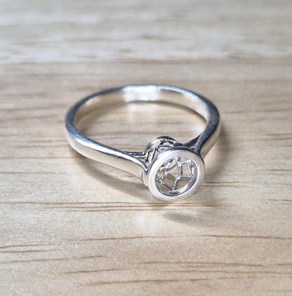 Top view of a cathedral basket ring on a wooden background.