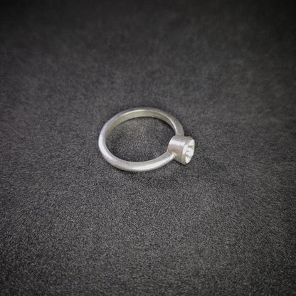 Right View of a Silver Bezel Ring on a Dark Background.