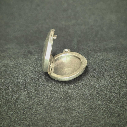 Bottom View of an Open Oval Silver Locket.
