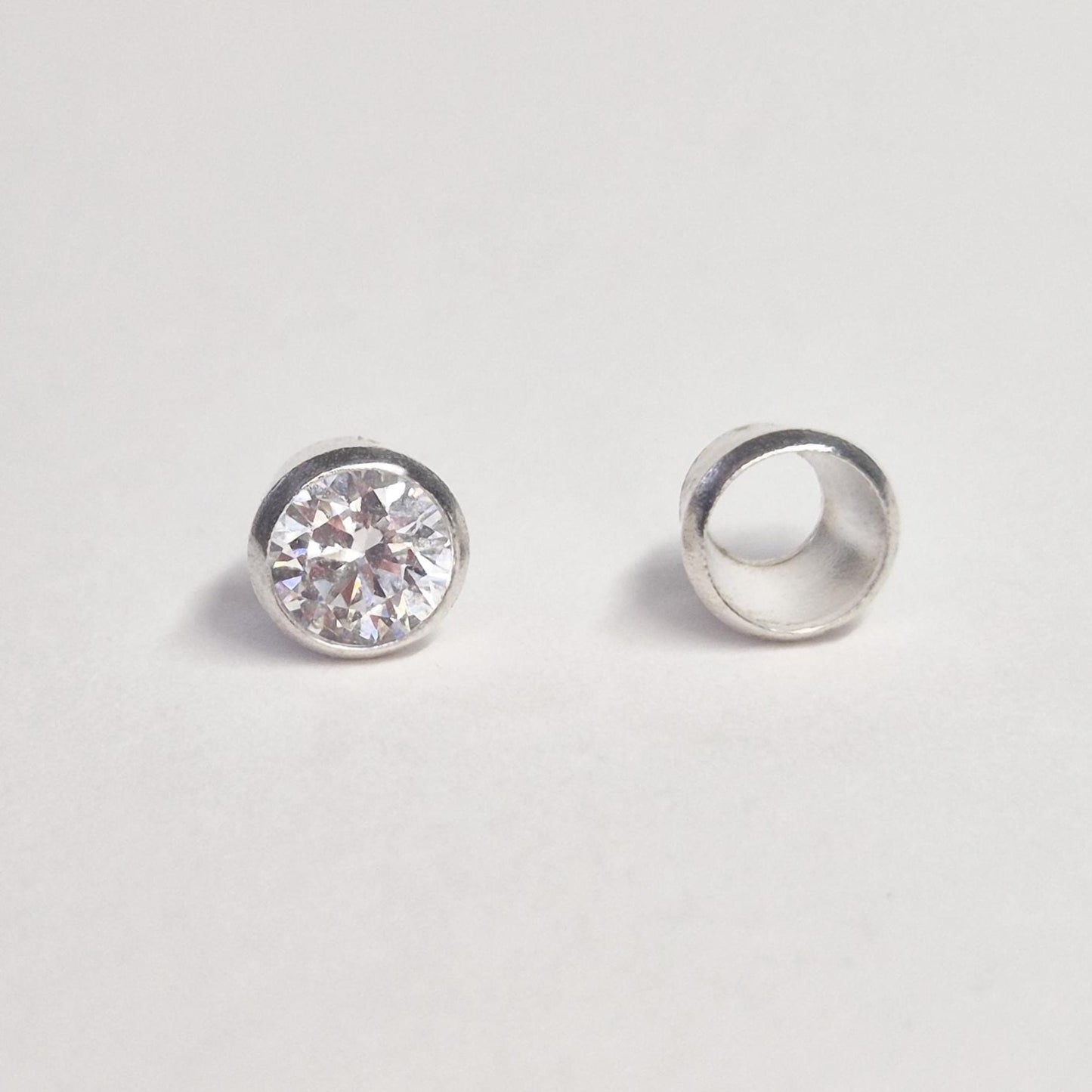 5mm sterling silver gemstone bezel setting next to finished mounted stone on white background for visual comparison.