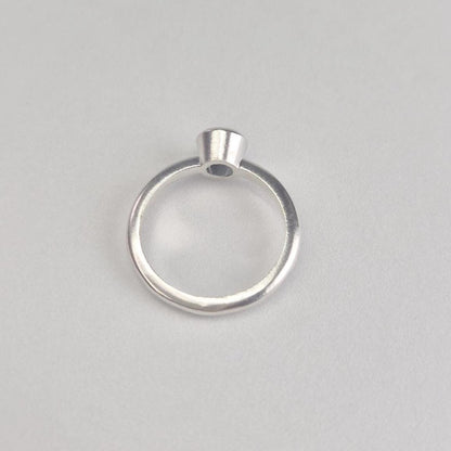 Silver Rubover Setting Ring on a White Background.