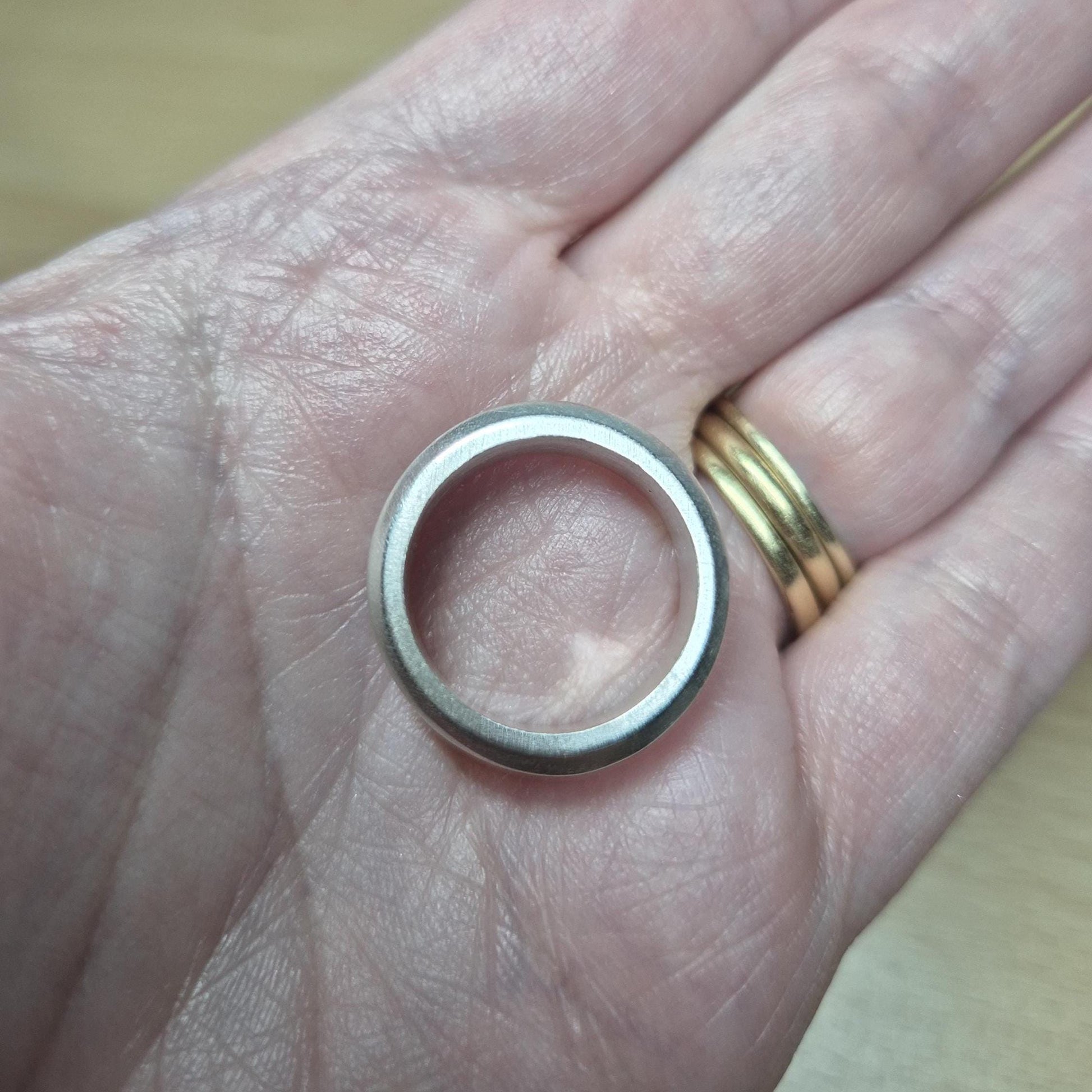 Top-down view of a half channel ring resting in a palm, highlighting the flat band profile and inner channel detail.