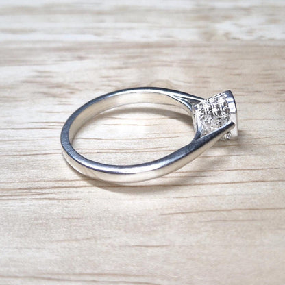 Angled overhead view of an emerald-cut ring blank, with visible cathedral shoulders and structured basket bezel setting.