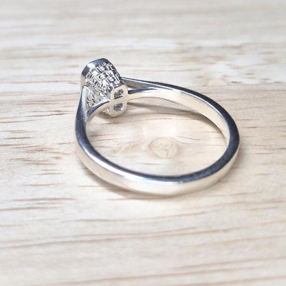Rear angle of a silver ring blank for emerald cut stones, emphasizing the openwork basket under-gallery.