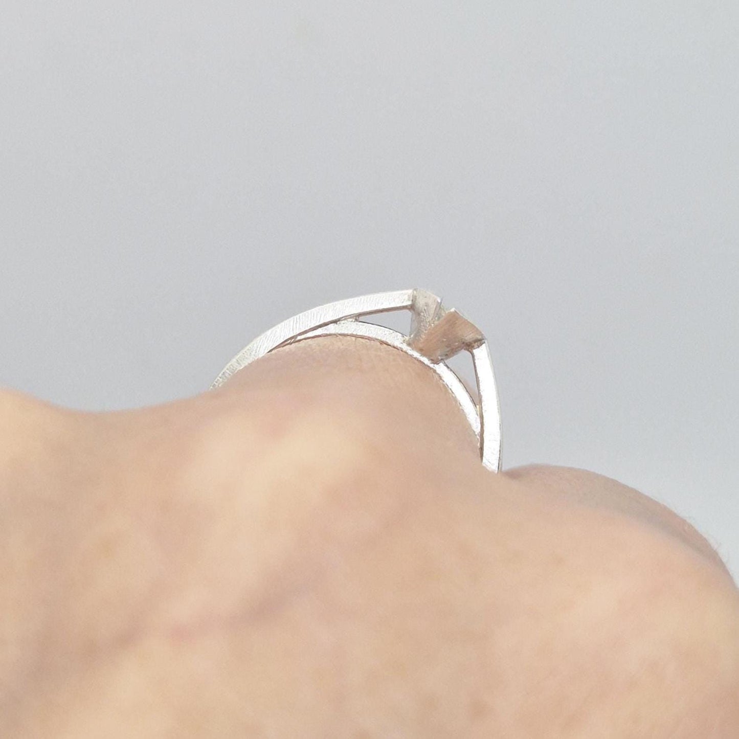 Close-up of a silver marquise split bezel ring blank on a hand, emphasizing the empty marquise-shaped split bezel setting and the ring&#39;s design on the finger.