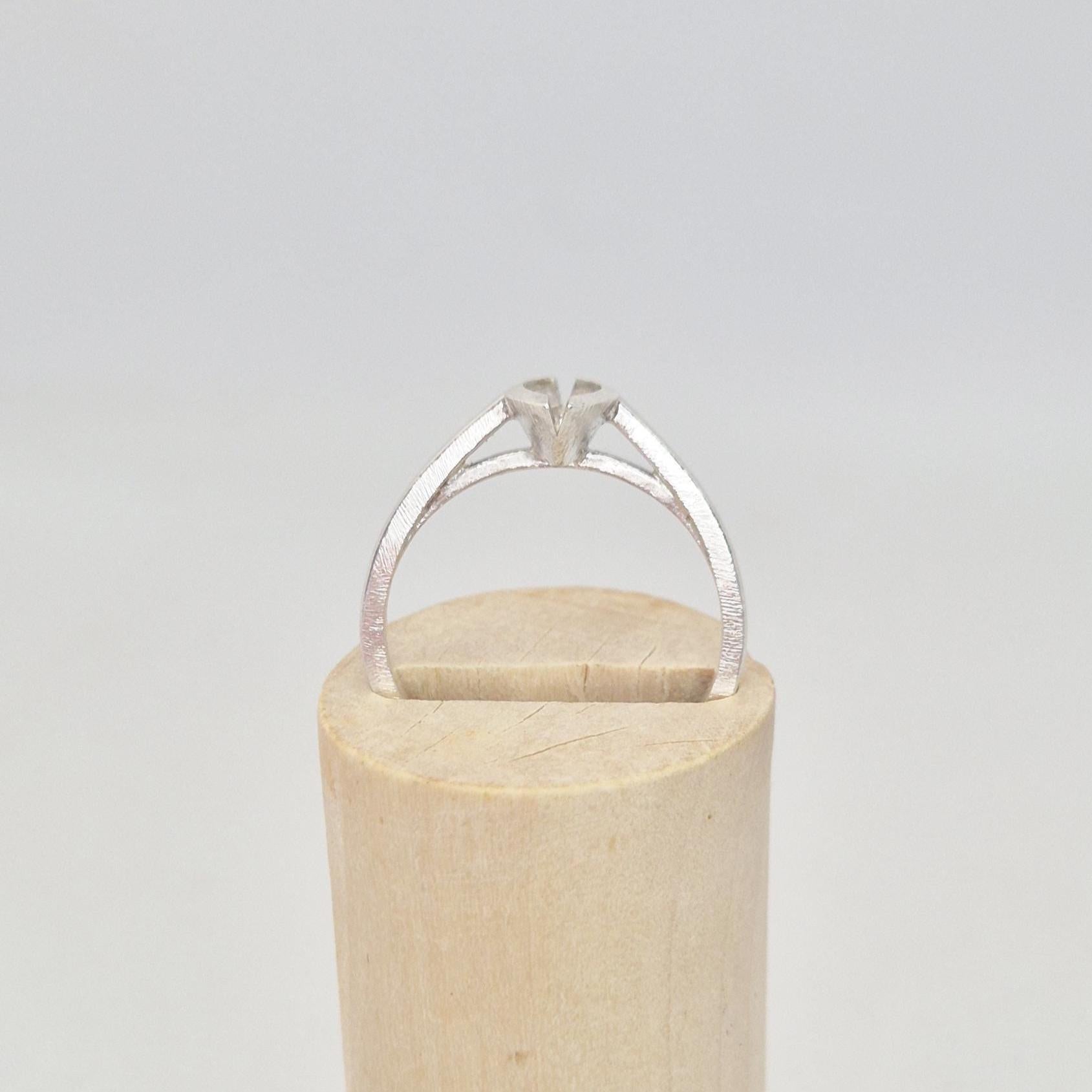 Silver marquise split bezel ring blank inserted into a cylindrical wooden ring holder, front view, highlighting the empty marquise-shaped split bezel setting.