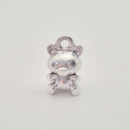Front view of solid silver teddy bear charm with rounded ears and seated pose, polished finish