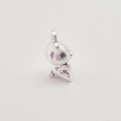 Angled view of silver teddy bear charm showing dimensional body and rounded detailing
