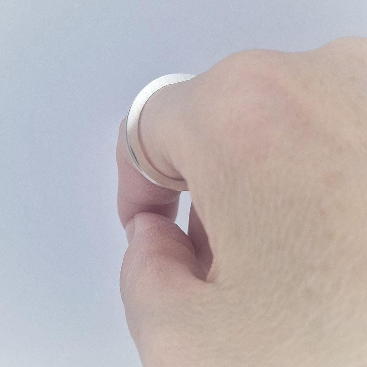Side view of a slim silver 120° channel band worn on the hand, highlighting the fine channel detail along the ring.