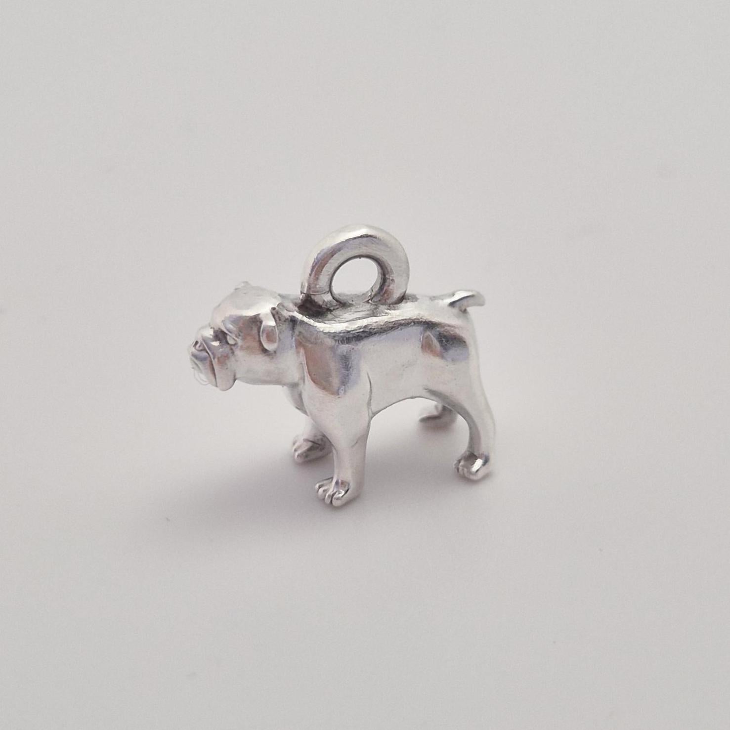 Side view of a silver bulldog charm with integrated top loop, photographed against a clean white background.