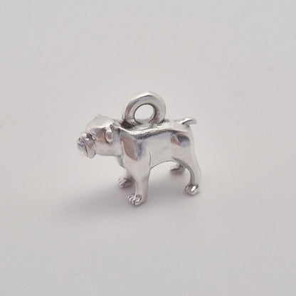 Side view of a silver bulldog charm with integrated top loop, photographed against a clean white background.