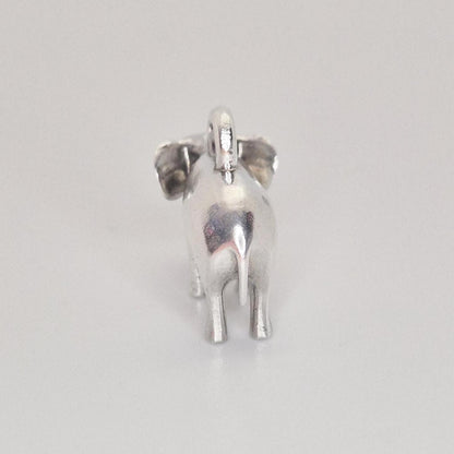 Rear view of a silver elephant charm against a white background, highlighting the tail, back legs, and smooth cast finish.