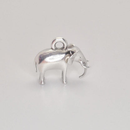 Front three-quarter view of a silver elephant charm on a white background, emphasising the trunk, ears, and solid proportions.