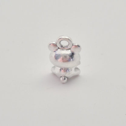 Rear view of small silver teddy bear charm highlighting smooth back and polished surface