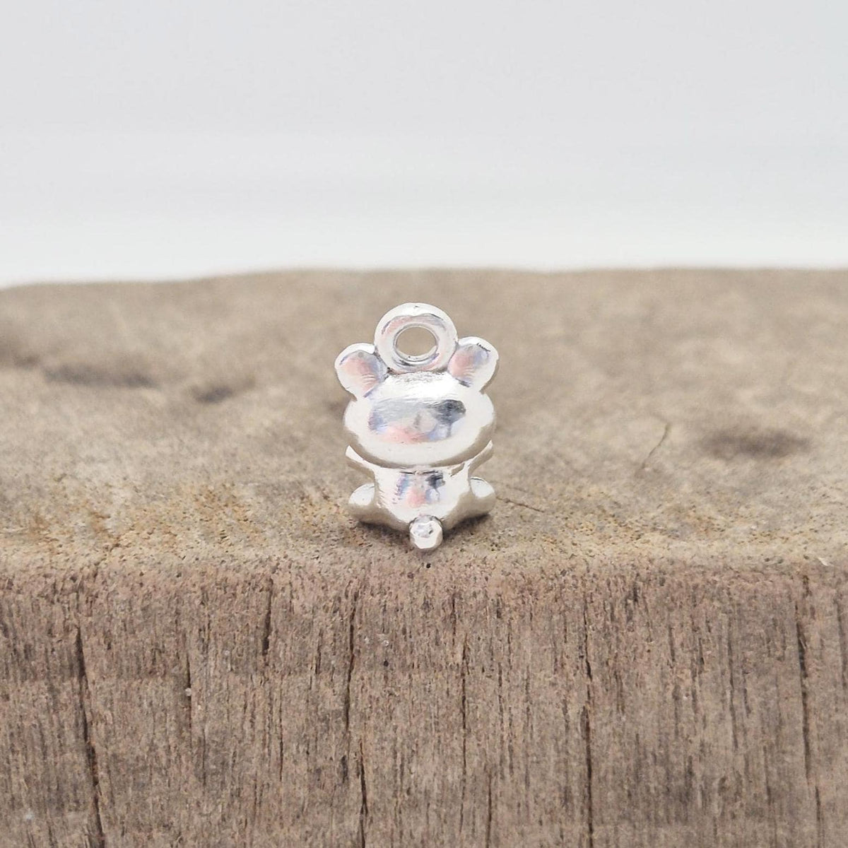 Rear detail of silver teddy bear charm showing compact seated design